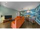 Bright living room with a large orange sectional couch, and a unique blue accent wall at 6630 E Virginia Ave, Denver, CO 80224