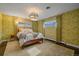 Cozy bedroom with floral wallpaper, plush bedding, large windows, and bright natural light at 6630 E Virginia Ave, Denver, CO 80224