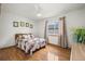A well-lit bedroom featuring a bed with a quilt and wood floors at 11861 Fairplay St, Commerce City, CO 80603