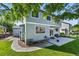 View of the back exterior with blue siding, well kept lawn and landscaping at 11861 Fairplay St, Commerce City, CO 80603