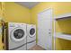 A clean laundry room with a washer, dryer, and tile flooring at 11861 Fairplay St, Commerce City, CO 80603