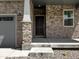 Inviting entrance with a stone facade, a sturdy front door, and a well-lit porch for added security at 546 Red Rock Pl, Brighton, CO 80601