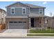 Attractive two-story home with stone veneer, siding, manicured lawn, and a convenient two-car garage at 546 Red Rock Pl, Brighton, CO 80601