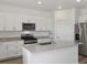 Bright kitchen with white cabinetry, stainless steel appliances, granite countertops, and a center island at 546 Red Rock Pl, Brighton, CO 80601