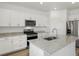 Modern kitchen with white cabinets, granite countertops, stainless steel appliances, and a kitchen island at 546 Red Rock Pl, Brighton, CO 80601