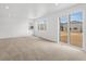 A sunlit living room with large sliding glass doors to the backyard at 546 Red Rock Pl, Brighton, CO 80601