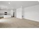 Open concept living space with plush carpet, breakfast bar, modern kitchen and stainless appliances at 546 Red Rock Pl, Brighton, CO 80601
