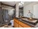 Bathroom featuring double hammered copper sinks, dark tile flooring, granite countertops and glass enclosed shower at 11716 W Belleview Dr, Littleton, CO 80127