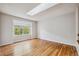 Bright bedroom with hardwood floors, a skylight, and a large window at 11716 W Belleview Dr, Littleton, CO 80127