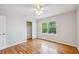 Bright bedroom features gleaming hardwood floors, large window, ceiling fan and closet with sliding doors at 11716 W Belleview Dr, Littleton, CO 80127