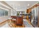 Modern kitchen featuring an island with stools, stainless steel appliances, and hardwood floors at 11716 W Belleview Dr, Littleton, CO 80127