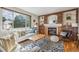 Inviting living room featuring a brick fireplace and large windows at 11716 W Belleview Dr, Littleton, CO 80127