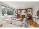 Bright living room with hardwood floors, brick fireplace, and comfortable seating at 11716 W Belleview Dr, Littleton, CO 80127