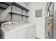 Laundry room features white washer and dryer with shelving, plus utility equipment at 9409 W 89Th Cir, Broomfield, CO 80021