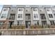 Townhome exterior with a gray facade, balconies, and landscaped front yard at 8711 E Hampden Ave # 23, Denver, CO 80231
