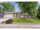 Charming home with well-maintained lawn, mature tree, and brick accents at 9306 Garrison Dr, Broomfield, CO 80021
