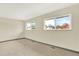 Bright bedroom with neutral walls, carpet, and large windows offering outdoor views at 12933 E Louisiana Ave, Aurora, CO 80012