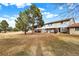 A well-maintained condo building shows an inviting front lawn with mature trees under a blue sky at 12933 E Louisiana Ave, Aurora, CO 80012