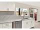 Renovated kitchen features white cabinets, stainless steel appliances, and backyard view at 12933 E Louisiana Ave, Aurora, CO 80012