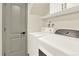The laundry room is equipped with a washer, dryer, and a gray utility door at 12933 E Louisiana Ave, Aurora, CO 80012