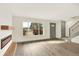 Bright living room with wood-look floors, a modern fireplace, and large windows offering an outdoor view at 12933 E Louisiana Ave, Aurora, CO 80012