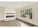 Bright living room with wood-look floors, a modern fireplace, and large windows offering an outdoor view at 12933 E Louisiana Ave, Aurora, CO 80012