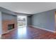 Open living room featuring hardwood floors, brick fireplace, and sliding door to the outside at 14204 E 1St Dr # A12, Aurora, CO 80011