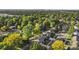 This aerial view showcases a quiet residential street surrounded by lush greenery and mature trees at 3565 S Holly St, Denver, CO 80237