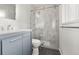 Updated bathroom with a glass enclosed shower, light blue vanity, and modern fixtures at 3565 S Holly St, Denver, CO 80237