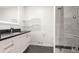 Modern bathroom with a sleek vanity, glass shelves, and a tiled walk-in shower at 3565 S Holly St, Denver, CO 80237