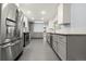 Updated kitchen with stainless steel appliances, granite countertops, gray cabinets, and tiled floors at 3565 S Holly St, Denver, CO 80237