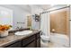 Well-maintained bathroom with a large vanity, stylish mirror, and a shower-tub combination at 10288 Olathe Way, Commerce City, CO 80022