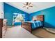 Bright bedroom with blue walls, a ceiling fan, a wooden bed frame and plenty of natural light at 10288 Olathe Way, Commerce City, CO 80022