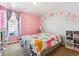 Charming bedroom featuring colorful decor, a comfortable bed, and ample natural light at 10288 Olathe Way, Commerce City, CO 80022