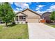 Charming home featuring stone accents, a covered porch, a well-manicured lawn, and an attached two-car garage at 10288 Olathe Way, Commerce City, CO 80022