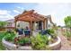 Back patio area with pergola and outdoor seating, framed by beautiful flowers and manicured landscaping at 10288 Olathe Way, Commerce City, CO 80022