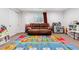 Bright playroom with colorful alphabet carpet, sofa, and various toys and bookshelves at 10288 Olathe Way, Commerce City, CO 80022