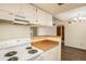 Cozy kitchen featuring an electric range, wooden countertops, and white cabinets at 3412 S Eagle St # 202, Aurora, CO 80014