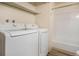 Convenient laundry room with a washer and dryer setup next to the bathroom with tub and shower at 3412 S Eagle St # 202, Aurora, CO 80014