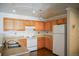 An eat-in kitchen with wood cabinets, track lighting and white appliances at 12158 W Dorado Pl # 204, Littleton, CO 80127