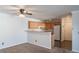An eat-in kitchen featuring wood cabinets and neutral countertops with a partial wall dividing it from the living space at 12158 W Dorado Pl # 204, Littleton, CO 80127