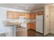 An eat-in kitchen features wood cabinets and all-white appliances at 12158 W Dorado Pl # 204, Littleton, CO 80127