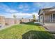 Lush backyard with a green lawn, privacy fence, and covered patio perfect for outdoor living at 27957 E 9Th Dr, Aurora, CO 80018