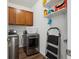 Functional laundry room with stainless steel washer and dryer, cabinetry, and shelves at 27957 E 9Th Dr, Aurora, CO 80018