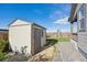 Backyard storage shed with neutral colors and a secure door, nestled within a well-maintained outdoor space at 27957 E 9Th Dr, Aurora, CO 80018