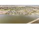 Wide aerial view of residential homes along a lake with lush green spaces and clear skies at 1738 Edgewater Pl, Longmont, CO 80504