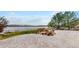Landscaped backyard with stone patio, lake view, and mature trees at 1738 Edgewater Pl, Longmont, CO 80504