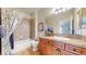 Bathroom showcasing a shower-tub combo, vanity with granite top, and blue floral shower curtain at 1738 Edgewater Pl, Longmont, CO 80504