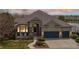Inviting home exterior featuring stone accents, covered porch, and a three-car garage at 1738 Edgewater Pl, Longmont, CO 80504