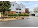 A well-maintained building exterior with brick accents, balconies, mature trees, and convenient parking spaces at 7665 E Eastman Ave # 202A, Denver, CO 80231